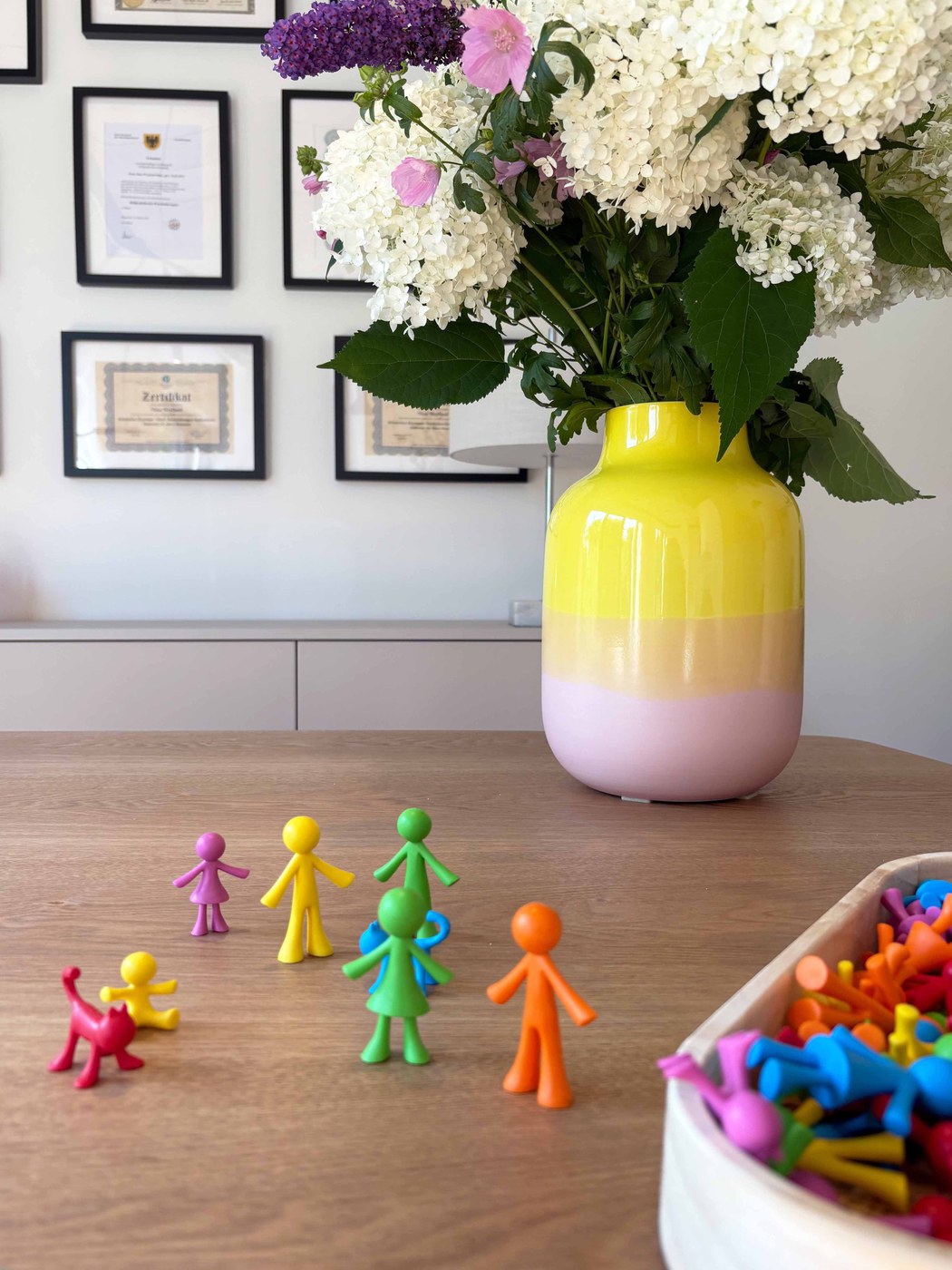 Bunte Figuren und ein Blumenstrauß auf dem Tisch in der Praxis