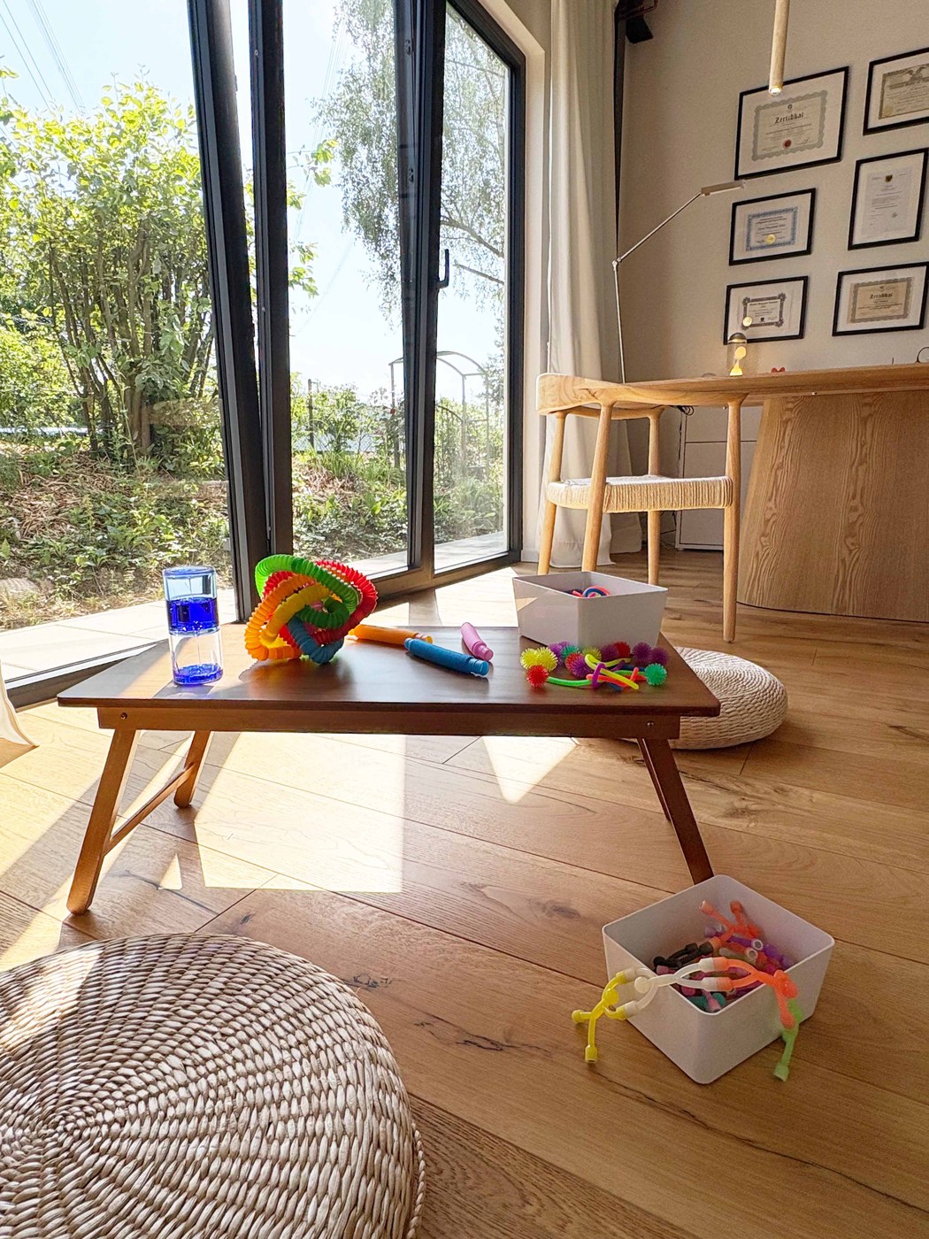 Spieltisch am bodentiefen Fenster mit Blick in den Garten