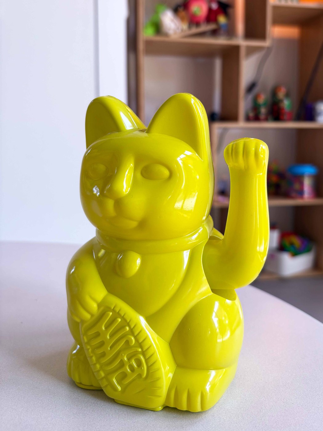 Gelbe Winkekatze auf dem Tisch in der Praxis